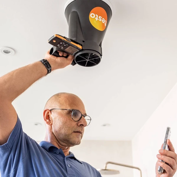 Engineer using the Testo 417 to check for air flow in a house