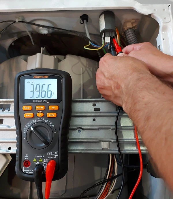 A engineer is using the hand-free magnetic hanging strap on the Socket & See Engineer DMM so it can log measurements