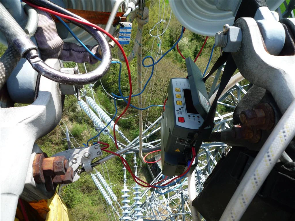 Using the hands-free hanging strap to hang the Megger DLRO10 Low Resistance Ohmmeter up high on a pylon
