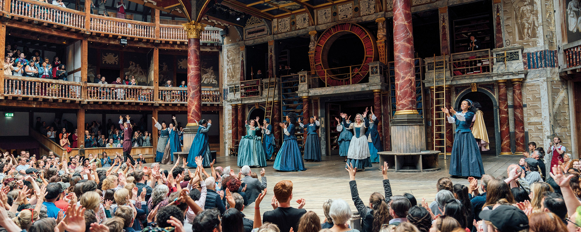 Emilia Memory Week Such Stuff Blogs and Features Masthead The cast of 'Emilia' gather on stage with their arms in the air, the yard audience also have their arms in the air