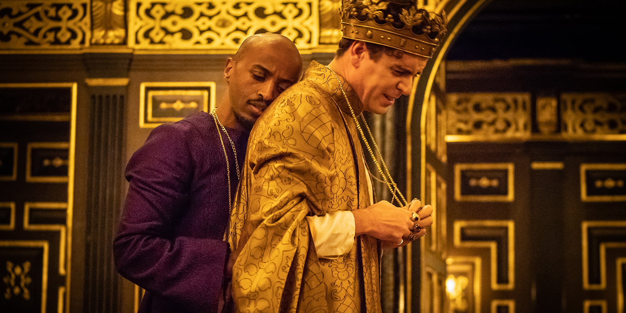 Edward II 2018 Shakespeare's Globe A male actors rests his head against the back of another male actor.