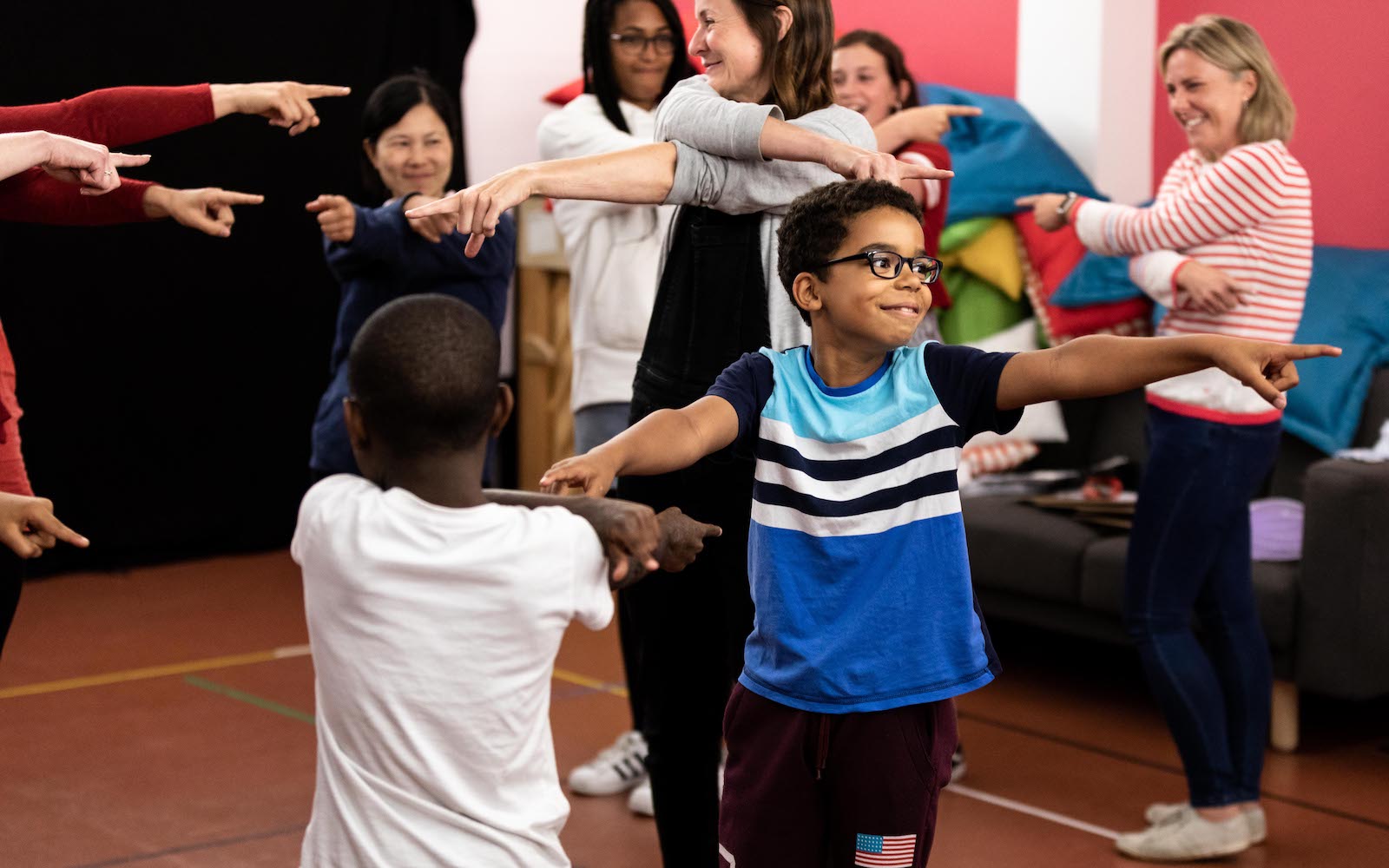 Family Events Two boys on their feet swing their arms in an interactive workshop