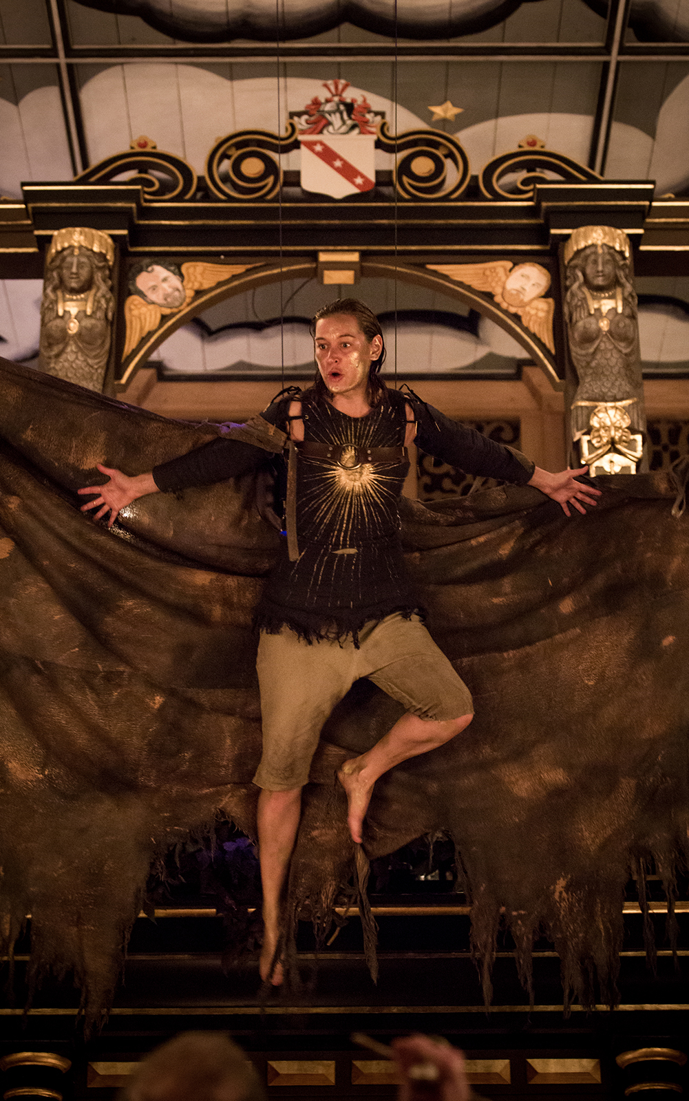 Airel The Tempest Sam Wanamaker Playhouse 2015 A woman with large wings and a painted gold face, hangs in the air of the Sam Wanamaker Playhouse.