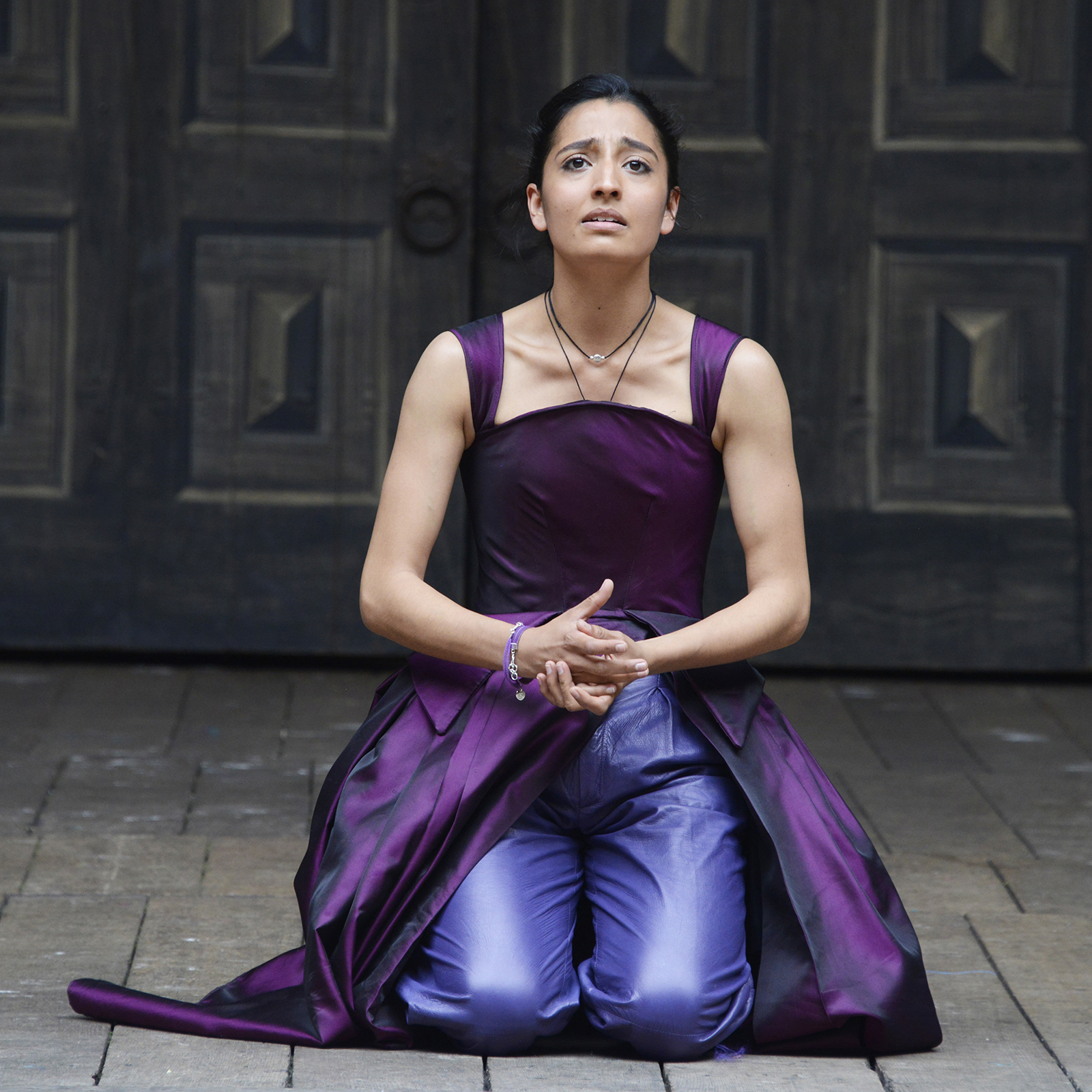 ©NOBBY CLARK+44(0)7941-515770+44(0)20-7274-2105nobby@nobbyclark.co.uk A woman wearing a bright purple gown kneels on the Globe stage, her hands clasped.
