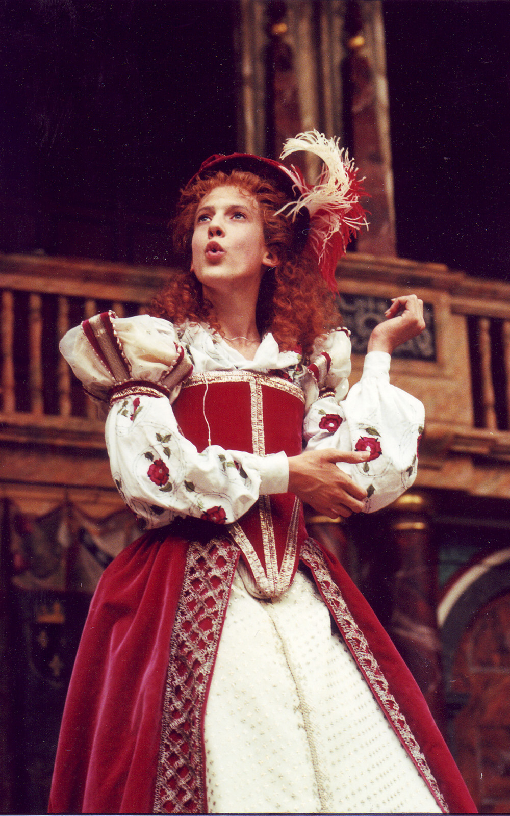 Henry V Globe Theate 1997 Katherine Shakespeare's Globe An actor wears a bright red traditional Elizabethan dress, with corset, puffed sleeves, and full skirt.