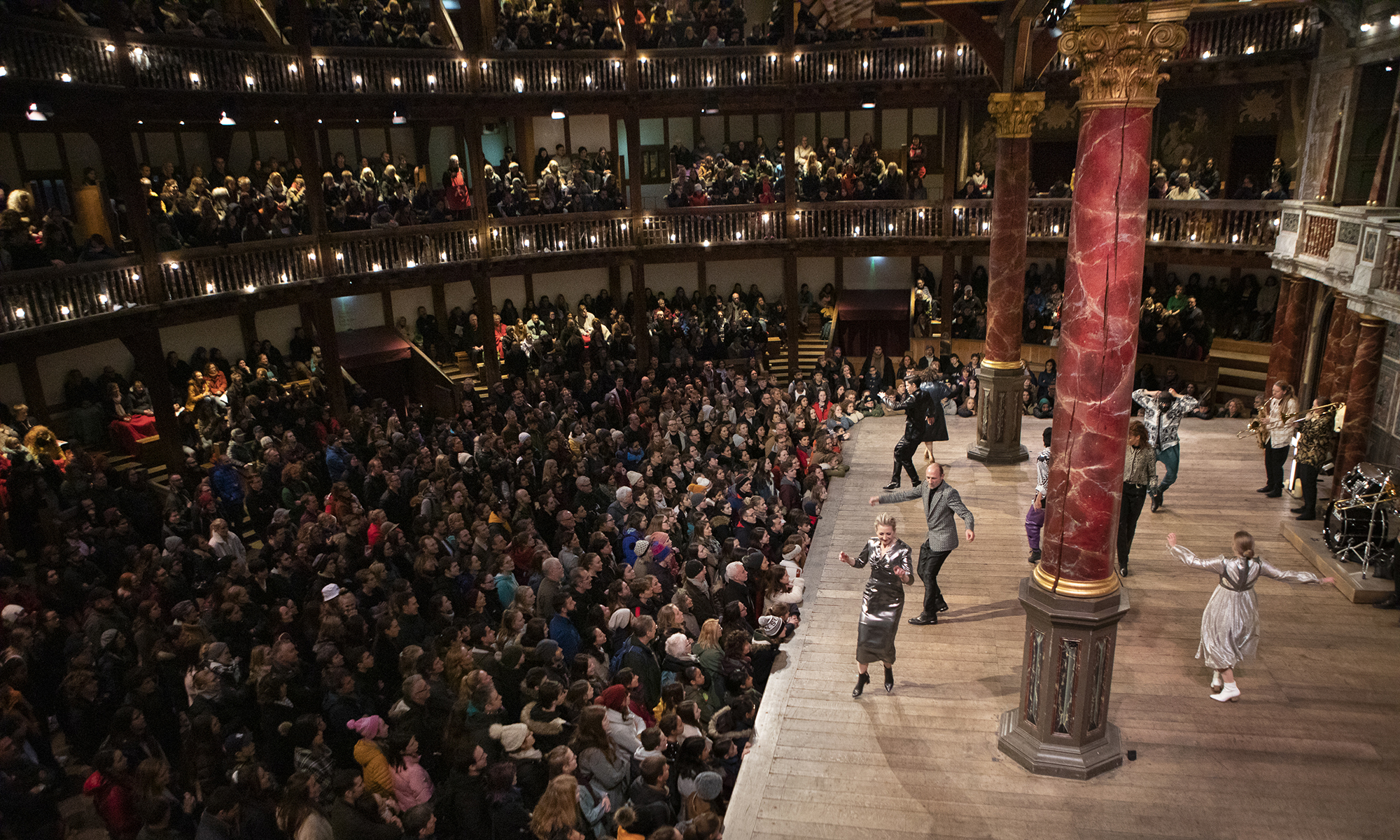 PSwithDB2019-RomeoandJuliet-PhotoEllieKurttz flush Actors dance on a wooden thrust stage, whilst a sea of audience members stand and watch.