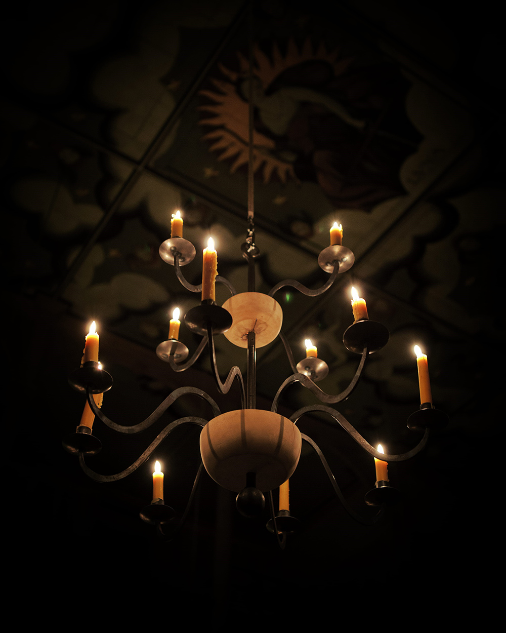 Candelabra Sam Wanamaker Playhouse Shakespeare's Globe A view looking up at a lit candelabra, the painted ceiling above.