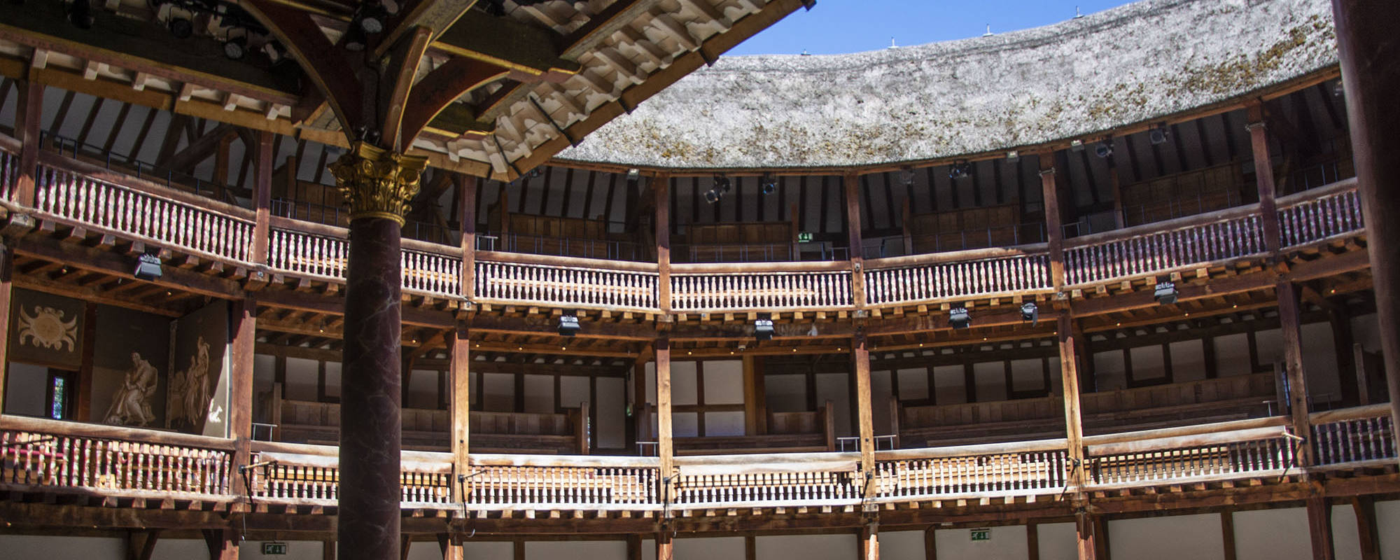 Shakespeare's Globe Culture Recovery Fund Sunlight streams into the yard of a wooden circular theatre.