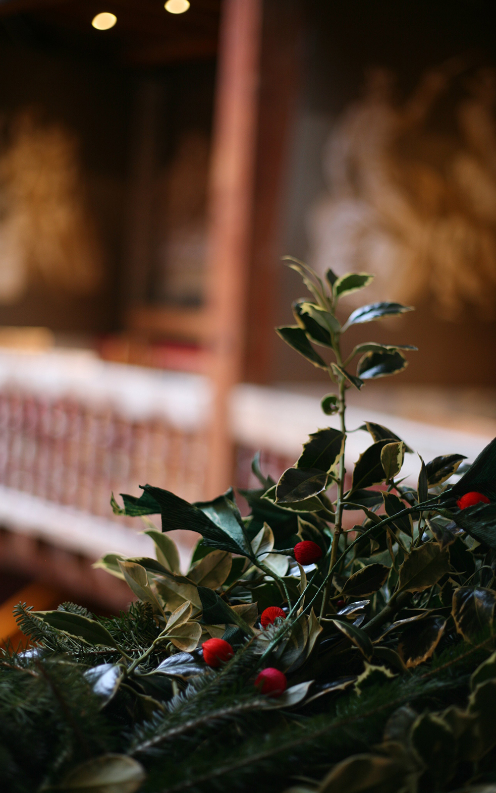 Holly Shakespeare's Globe Theatre Christmas 2020 A close up of a holly wreath wrapped around wooden banisters.