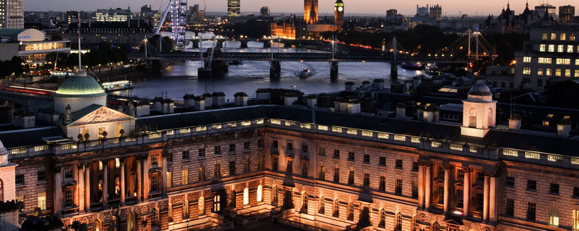 King's College London MA Shakespeare Studies 2 A wide nighttime shot of a large, white Neoclassical building, with the London skyline behind.
