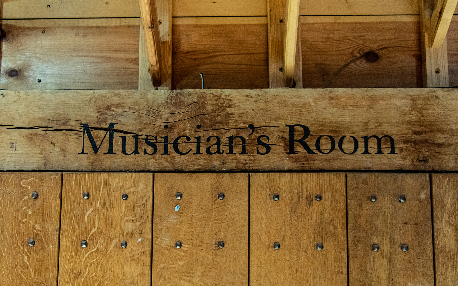 Heaven to Hell Globe Magazine Article Greg Morrison Musician's Room Black text goes across a wooden beam above a door