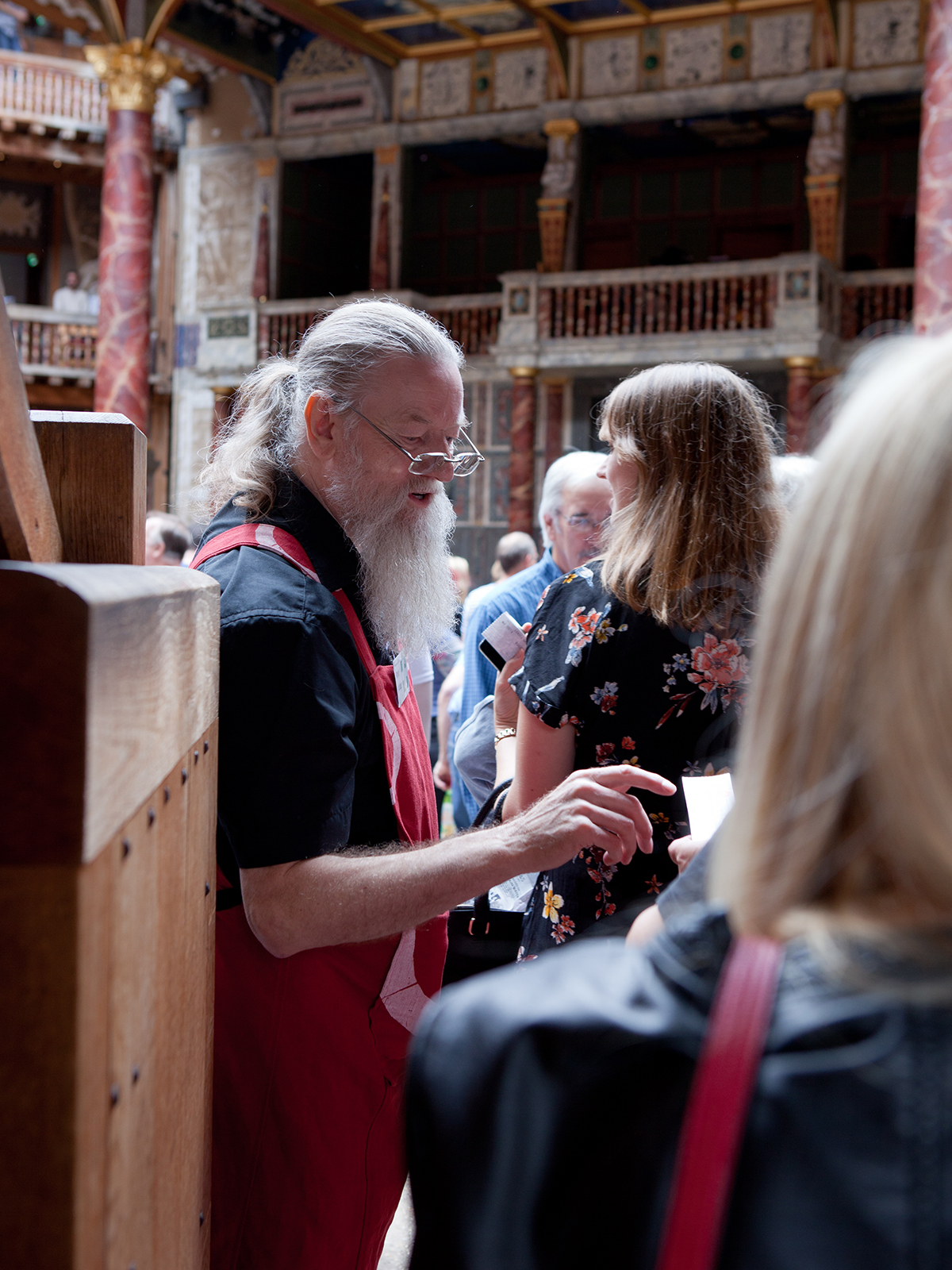 Globe Magazine Article Shakespeare's Globe volunteer stewards A man takes a ticket of an audience member entering a theatre