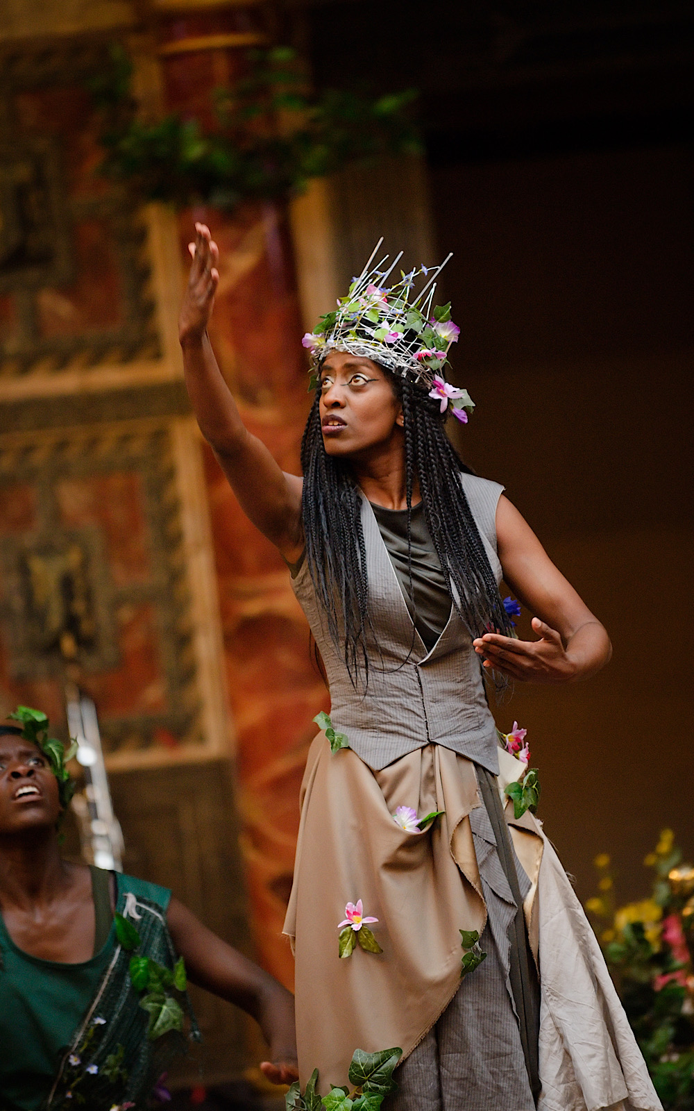 Discover Plays A Midsummer Night's Dream 2014 An actor performs on stage wearing a crown of flowers, with one arm lifted in the air