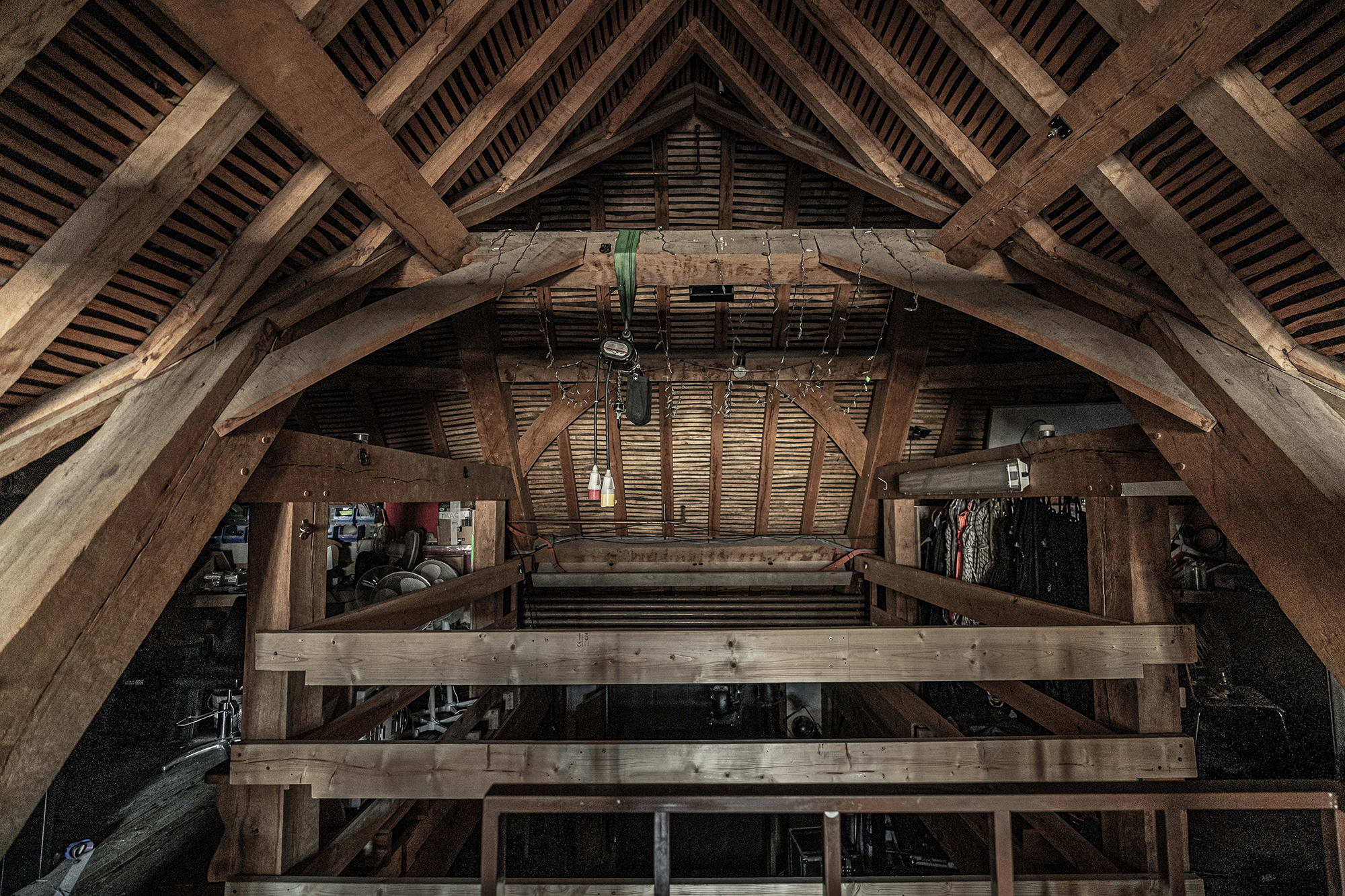 Globe Theatre Attic Marc Brenner Lockdown The inside of an attic with thatch roof and great oak beams. Various cables and objects hang from the rafters.