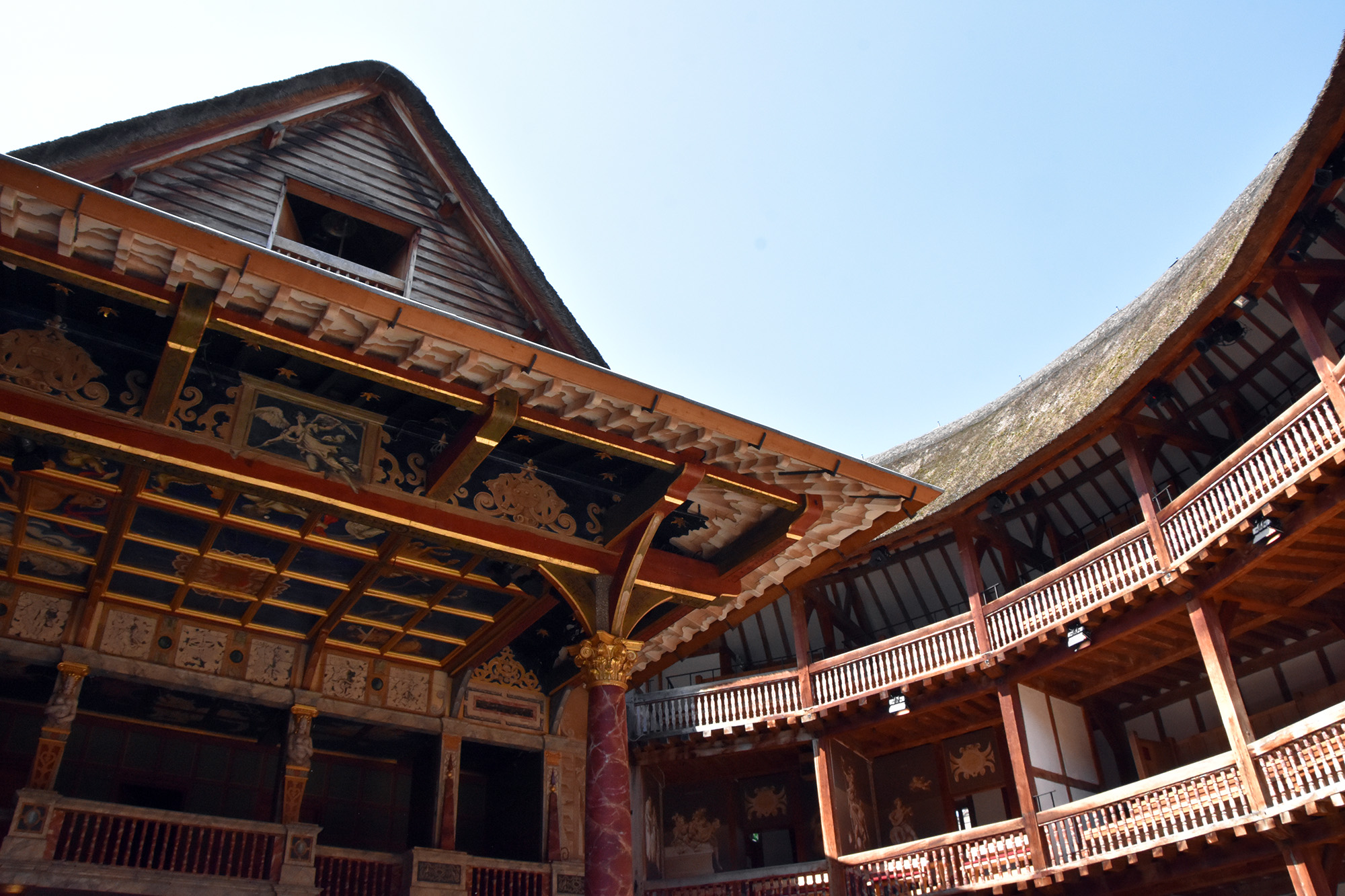 Shakespeare's Globe Lockdown One Year Later A soft blue sky shines above the inside of the Globe Theatre, casting light on the wooden galleries.