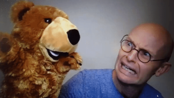 Telling Tales Exit Pursued by a Bear An animation of a teddy bear attacking a man, with a flag reading: Exit, pursued by a bear
