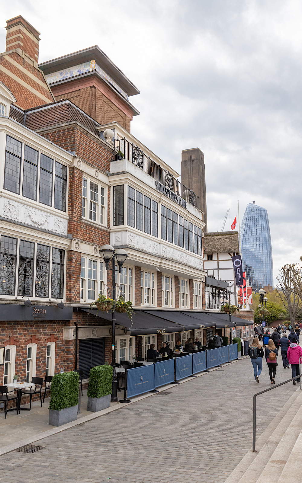 Guided Tours 2021 Pete Le May A tall brick building with outdoor restaurant seating