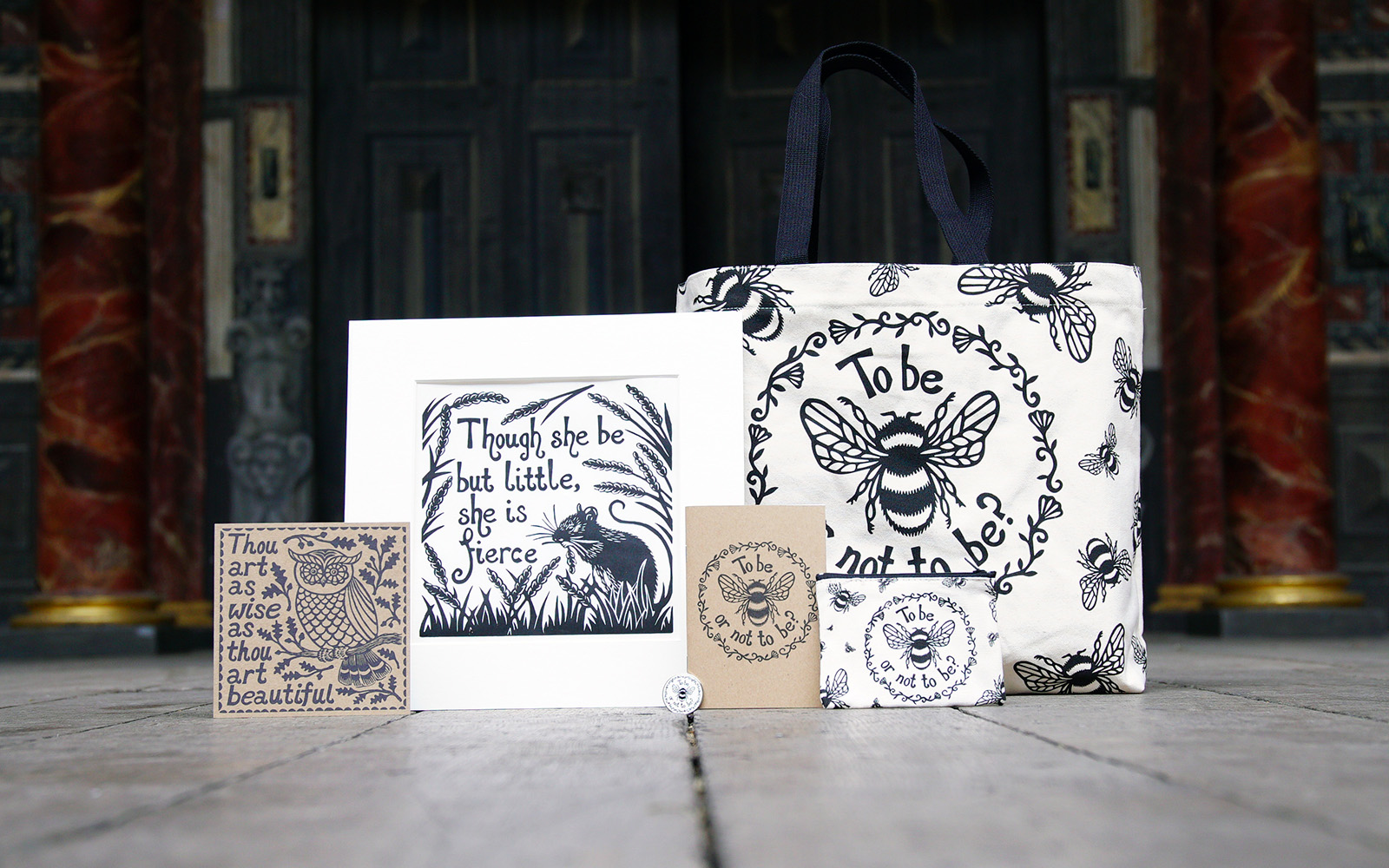 Rowan Tree Eco Range Shakespeare's Globe Shop card A selection of white and beige products, including a print, card, tote bag, notebook and purse, featuring a illustrative screen printing design of bees, flowers, and animals.