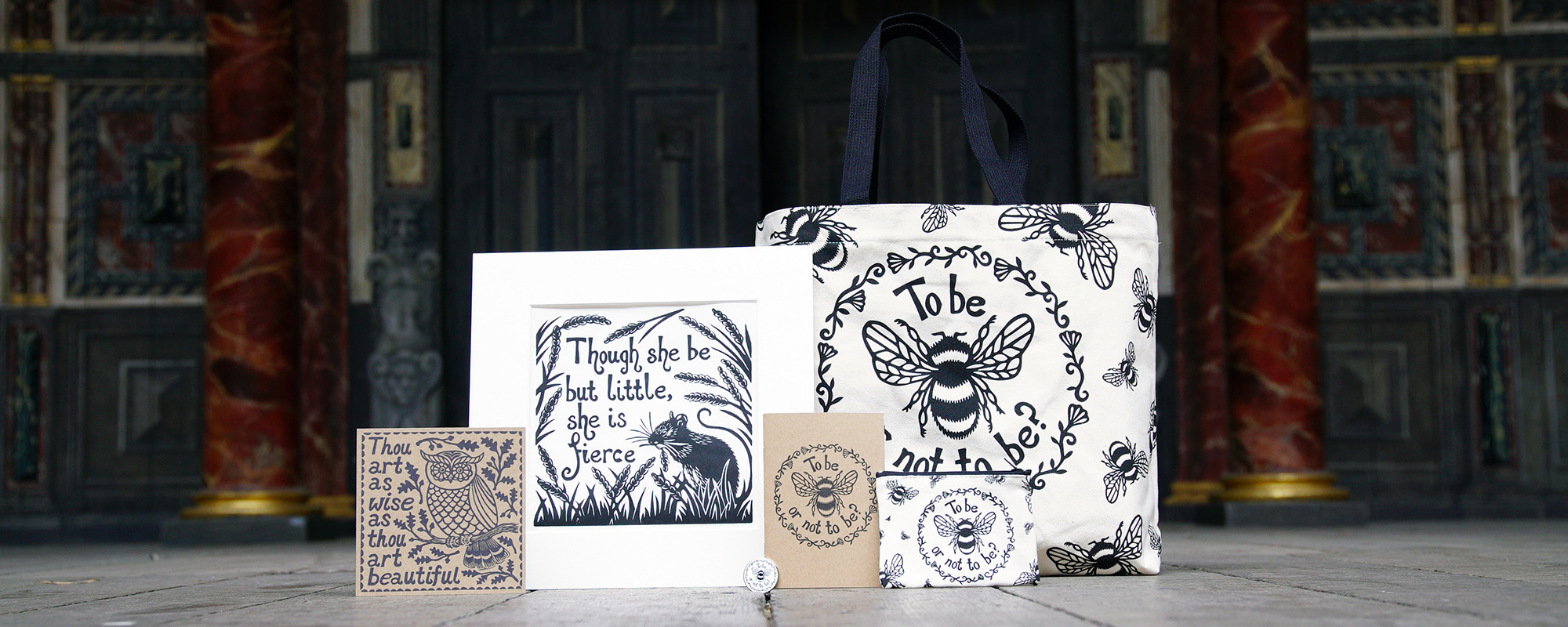 Rowan Tree Eco Range Shakespeare's Globe Shop A selection of white and beige products, including a print, card, tote bag, notebook and purse, featuring a illustrative screen printing design of bees, flowers, and animals.