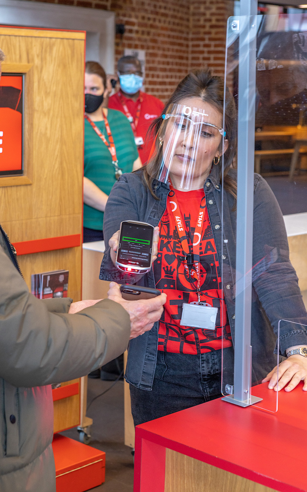 Covid Coronavirus Shakespeare’s Globe Pete Le May 2021 A member of staff in a visor uses a machine to scan a QR code on someone’s device