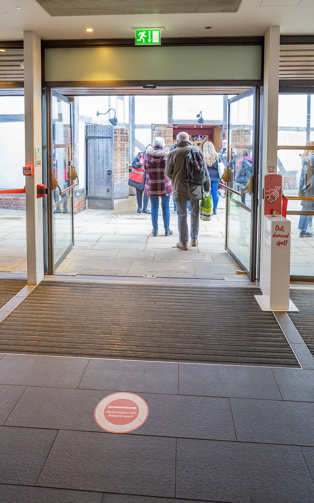 Covid Coronavirus Shakespeare’s Globe Pete Le May 2021 A wide, open door leads to an outdoor piazza where people are walking towards another door