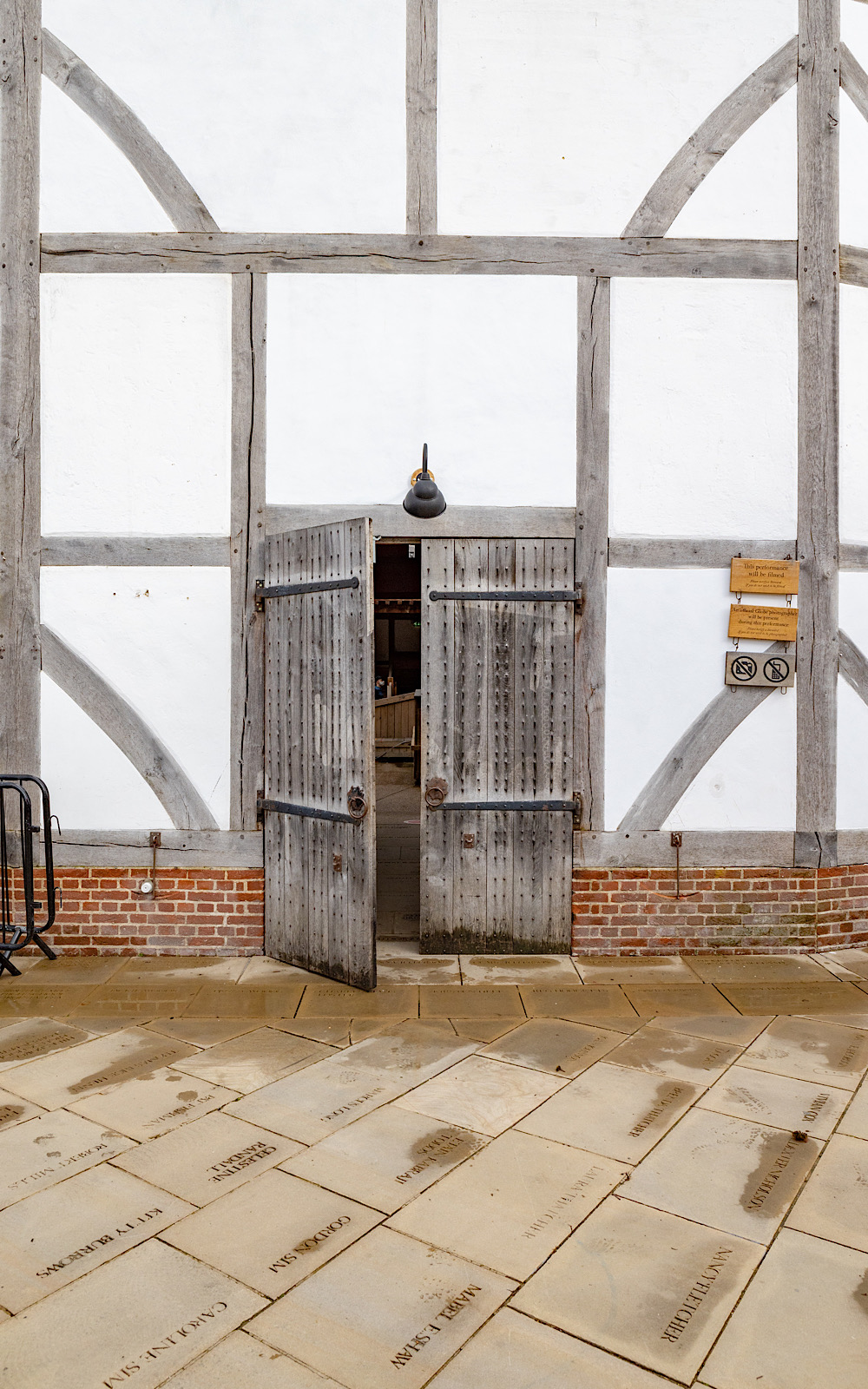 Covid Coronavirus Shakespeare’s Globe Pete Le May 2021 Within a white, wooden-beamed wall, a wooden pair of doors are open