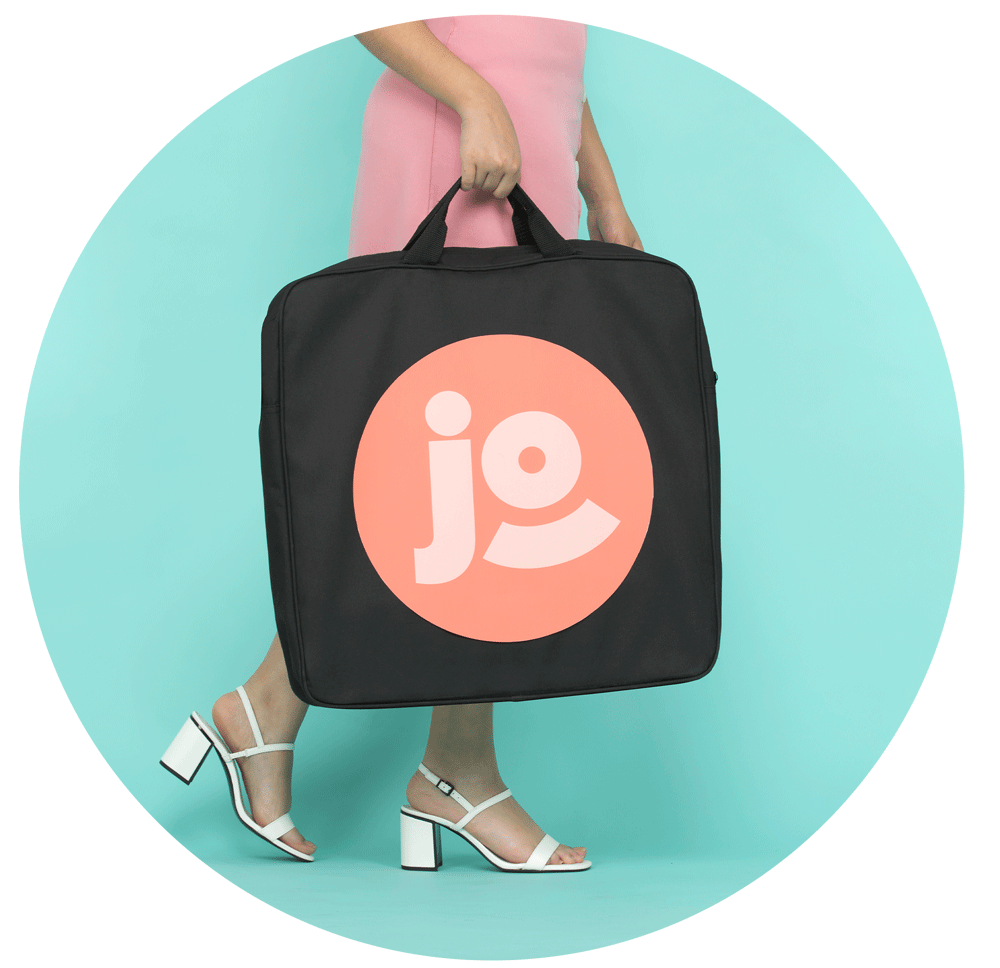 Une femme Ă un mariage porte le photobooth Josepho dans sa housse de transport. Le logo Josepho