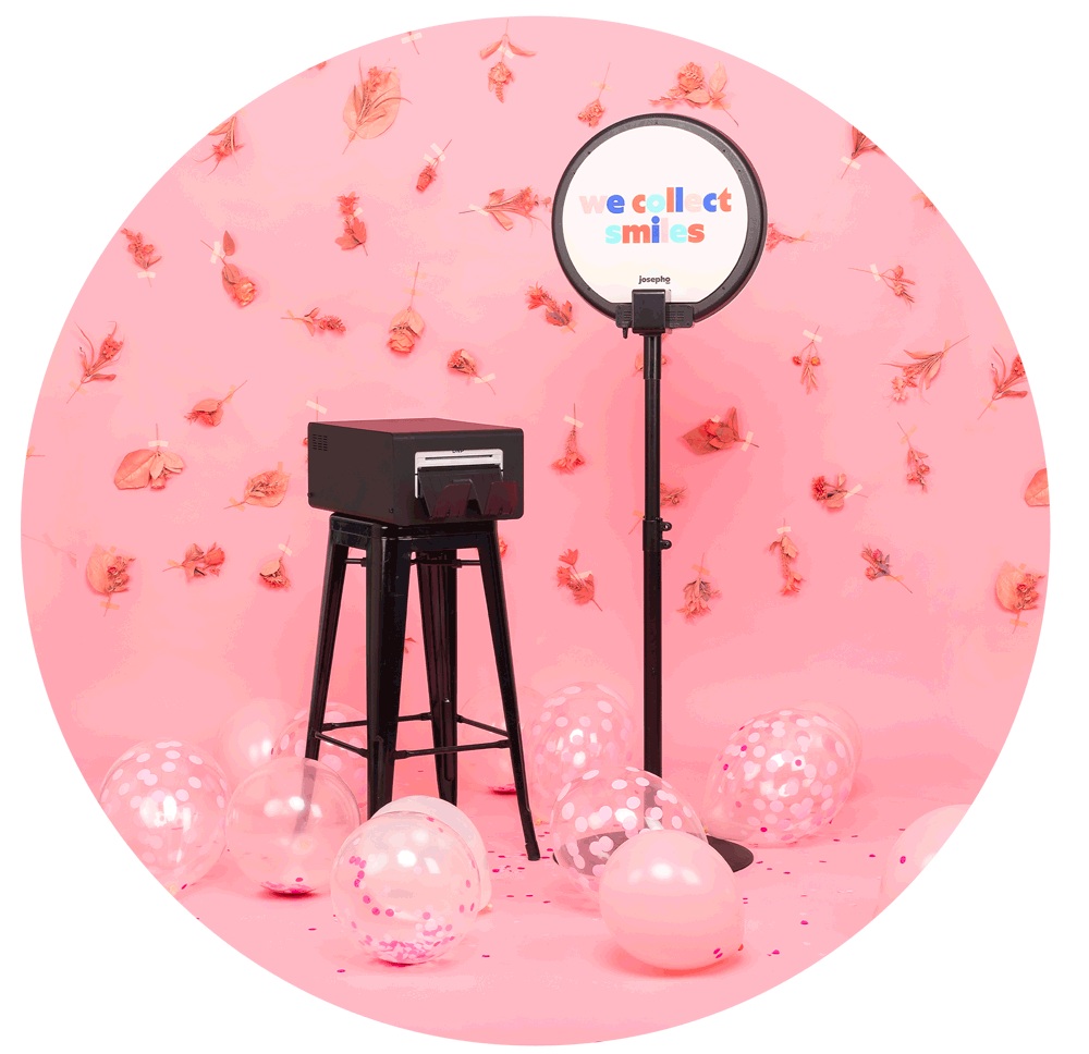 Le photobooth de Josepho est positionné de dos à côté de son imprimante pendant un mariage. La face arrière du photobooth est personnalisée avec le slogan