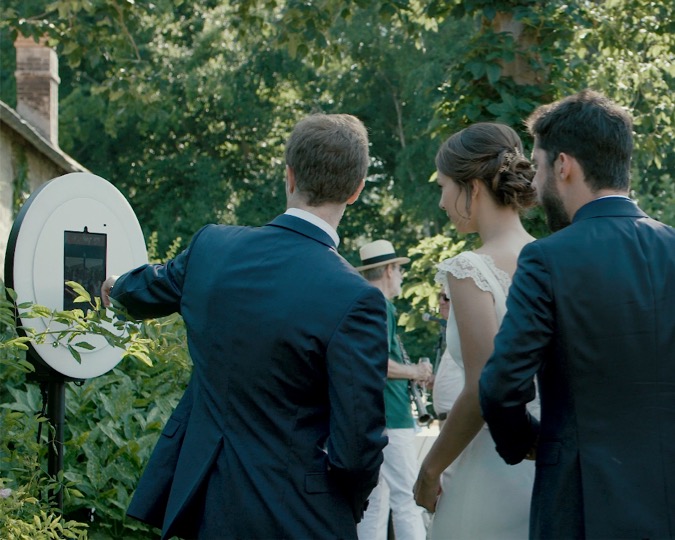 Lise et Antoine, un couple de nouveaux mariés, et un ami, se prennent en photo avec le photobooth de Josepho pendant leur mariage.