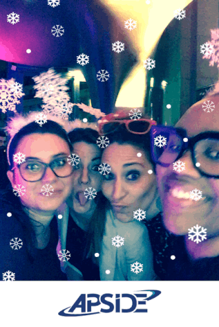 Un GIF animé pris avec le photobooth de Josepho montre 4 personnes qui sourient avec des serre-têtes flocons et une pluie de flocons tombent. Le GIF est personnalisé avec le logo de la société Apside.