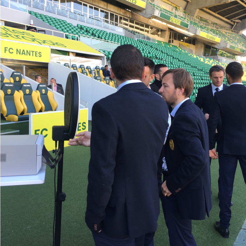Deux hommes se prennent en photo avec le photobooth Josepho qui est positionné dans le stade de la FC Nantes.