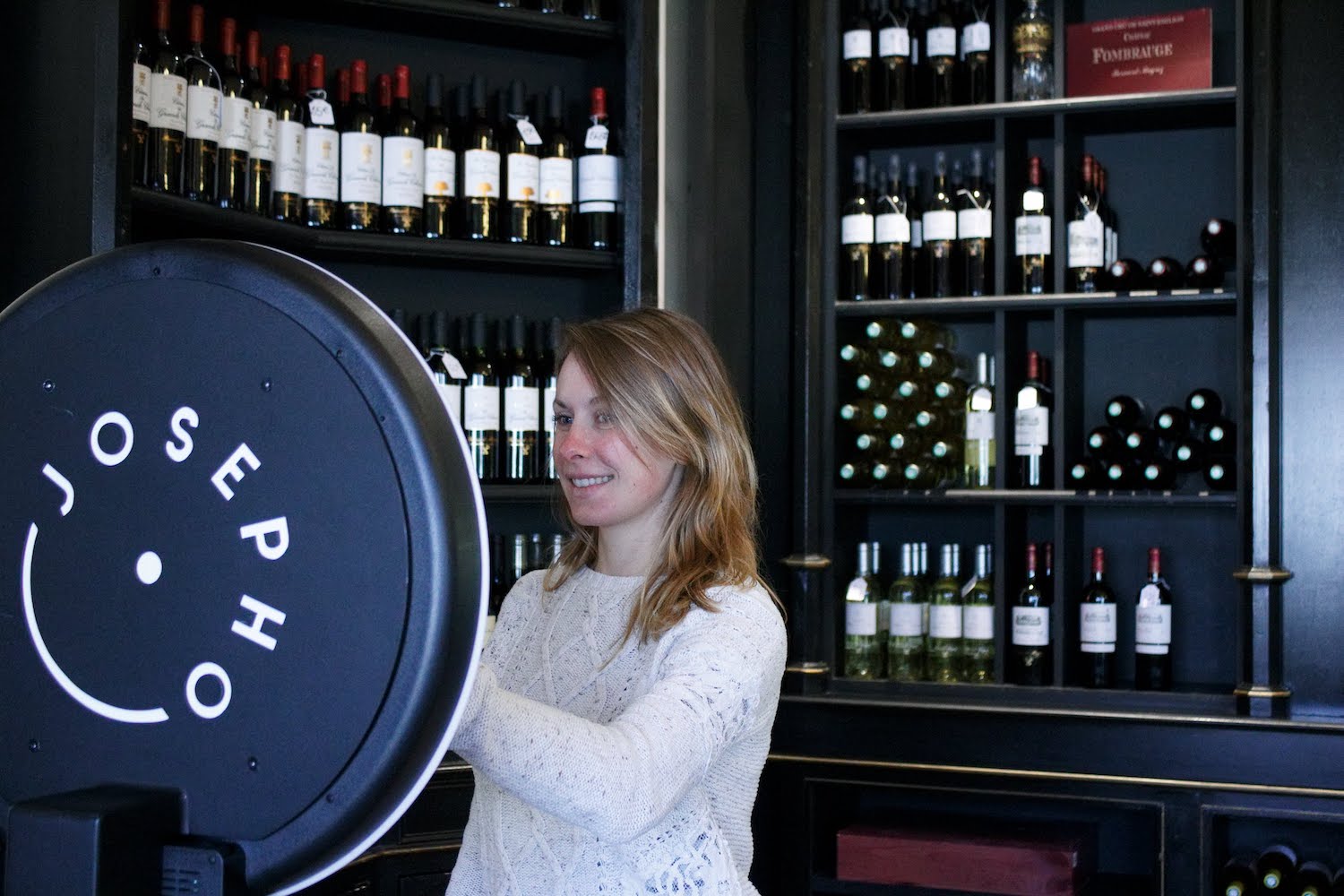 Une femme se prend en photo avec le photobooth de Josepho dans la boutique du Château Pape Clément.