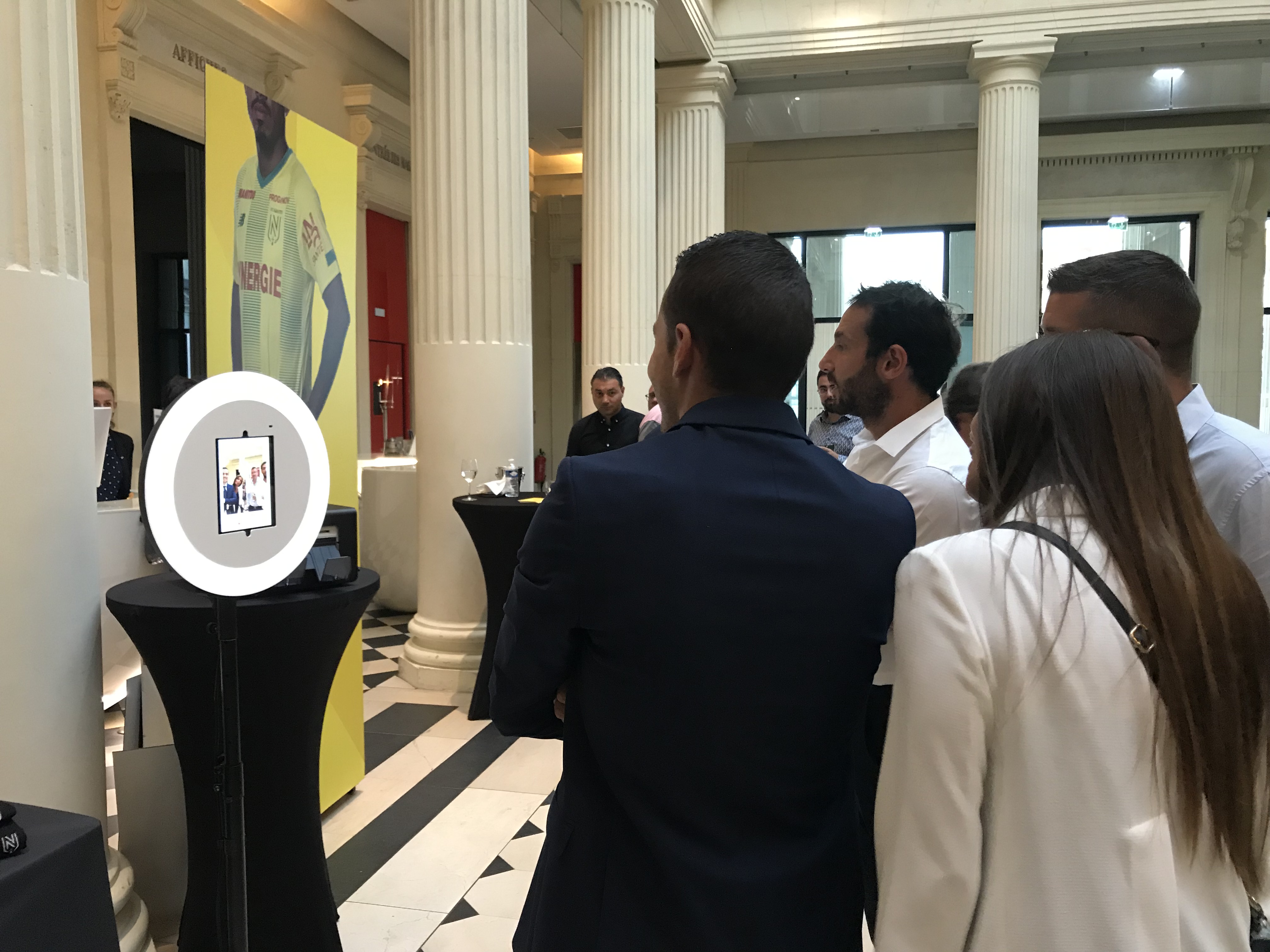 Un groupe de personnes se prend en photo avec le photobooth de Josepho durant la soirée partenaires du FC Nantes.