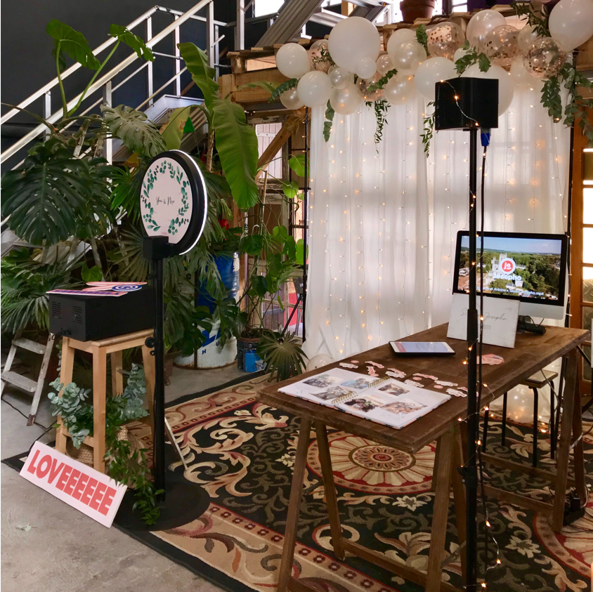 Le photobooth de Josepho est en présentation sur un stand sur le festival You & Me. Un photocall décoré dans le thème du mariage a été placé devant la borne photo.