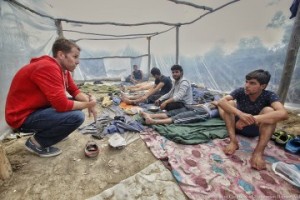 A Samaritan’s Purse staff member (in red) listens as young men share their journey from Iraq to Europe.