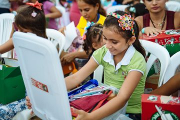 A child of one of the patients at the Samaritan’s Purse emergency field hospital smiles as she opens her shoebox gift. Samaritan’s Purse and local ministry partners held an Operation Christmas Child outreach event on June 1, International Children’s Day, for 580 children.