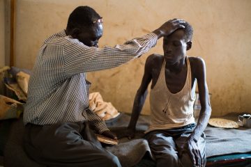 Pastor Andrea Aja prays over a patient.