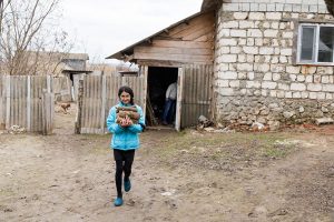 Natalia collecting logs to heat their home