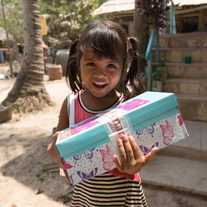 Smiling girl holding butterfly shoebox