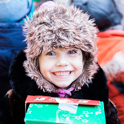 Girl with fluffy hat and shoebox gift