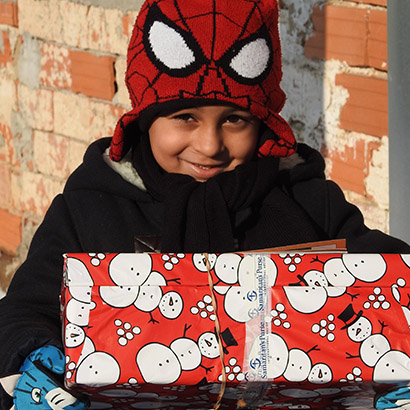 Boy in spiderman hat with red shoebox