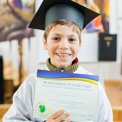 The Greatest Journey - boy at graduation with certificate and New Testament Bible