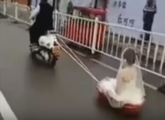 بالفيديو: عريس يسحب عروسه خلفه على دراجة بخارية