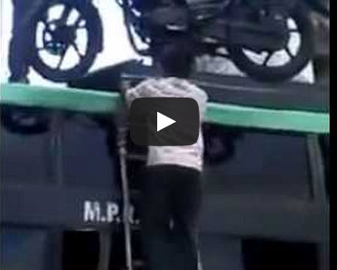 حمل دراجته النارية على رأسه ويعتلي بها الحافلة