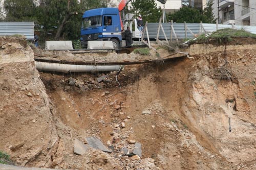 بالصور :  العمل لمنع انهيار شارع في عبدون