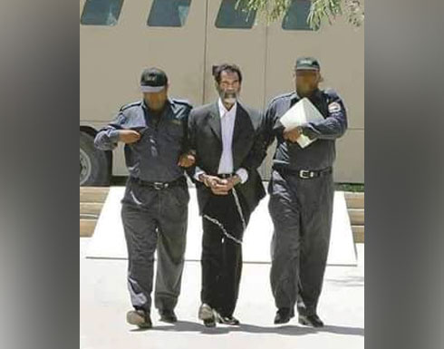 صورة لصدام حسين تنشر لأول مرة أثناء اقتياده مكبلاً الى ساحة المحكمة صورة لصدام حسين تنشر لأول مرة أثناء اقتياده مكبلاً الى ساحة المحكمة