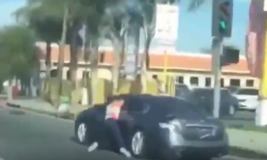 شاهد.. امرأة تتعلق بسيارة زوجها بعد ضبطه مع فتاة