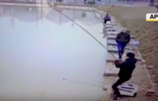 شاهد.. سمكة تسقط صياداً في الماء بعد أن علقت بسنارته