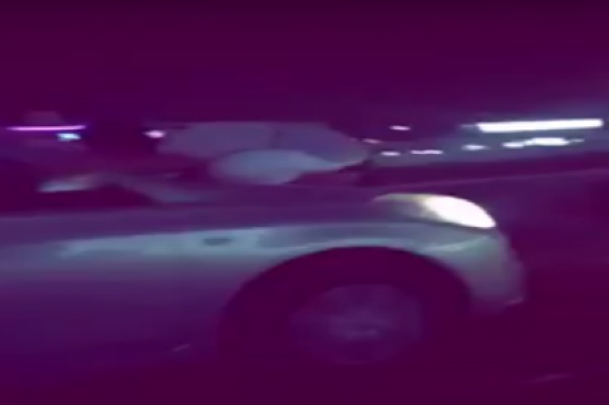 شاهد.. يقود بسرعة عالية وزميله فوق غطاء السيارة