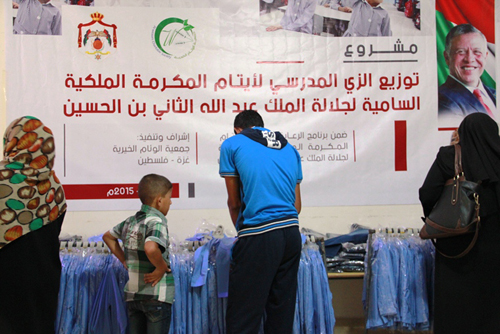 بالصور  : بمكرمة ملكية .. توزيع الزي المدرسي على ايتام " غزة "